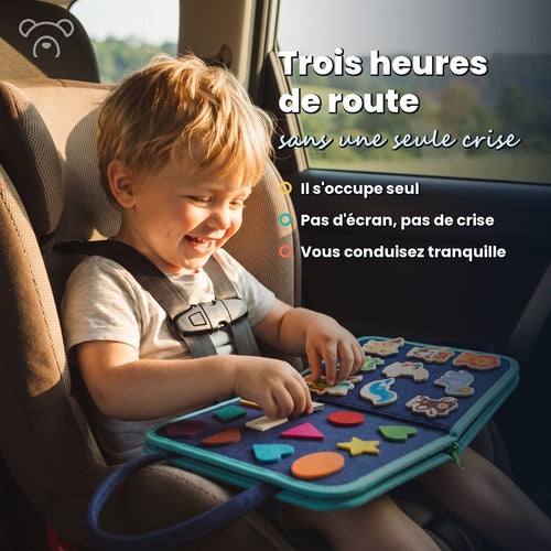 Enfant souriant dans son siège auto avec son busy board en feutre bleu #bleu