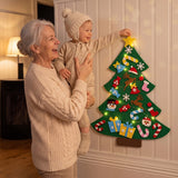 Grand-mère qui aide son petit-enfant à poser l'étoile sur le sapin en feutrine