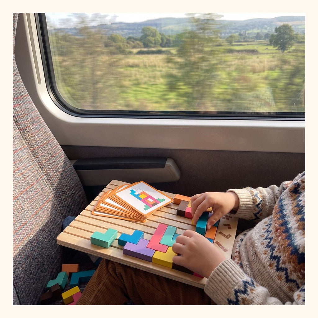 Enfant qui joue au Tetris en bois pendant un trajet en train